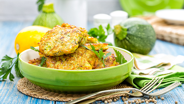 Stack of zucchini pancakes in a shallow green dish