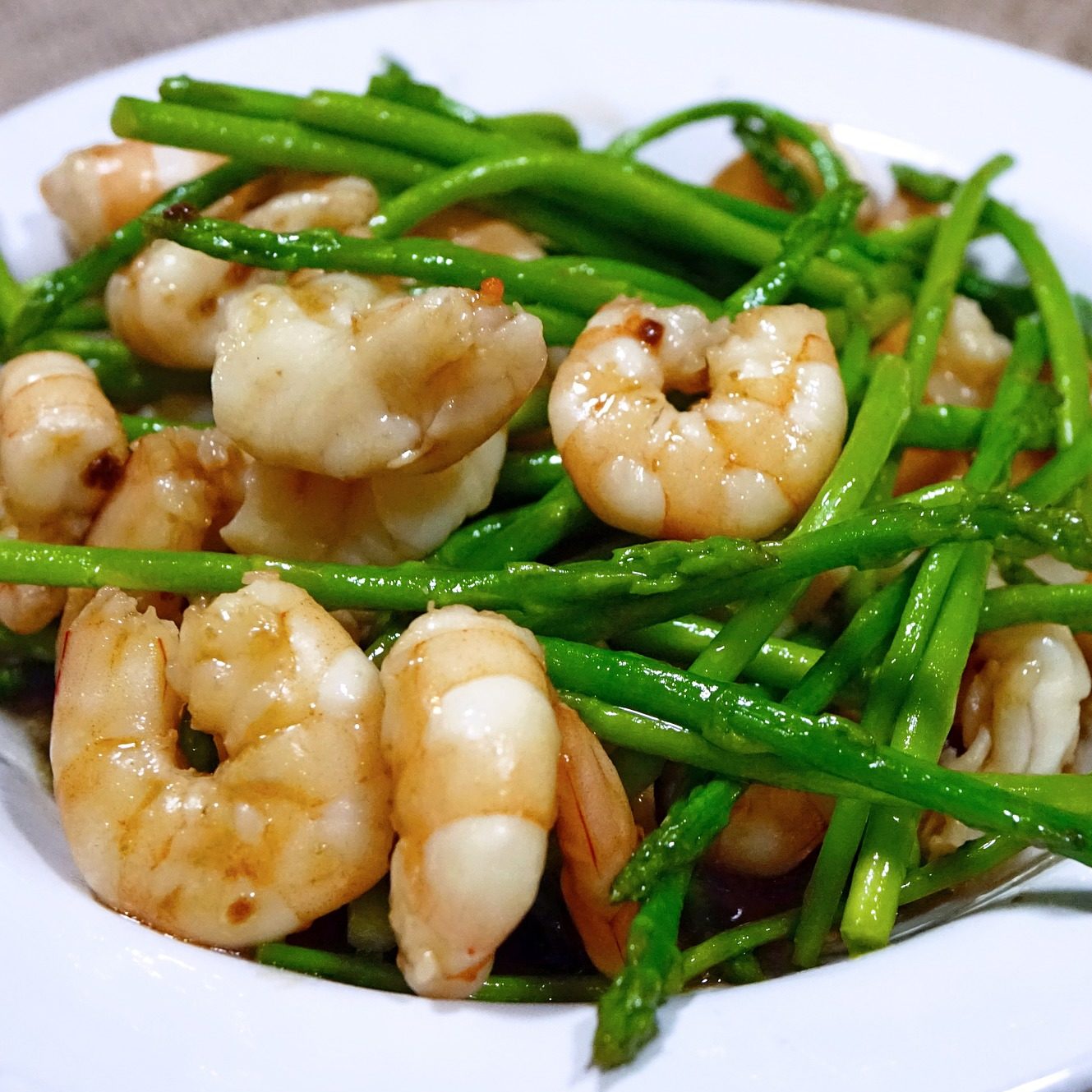 Close-up image of cooked shrimp and whole asparagus stalks