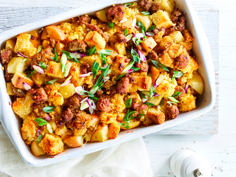 Baked stuffing with diced apples, diced sausage, and garnish.